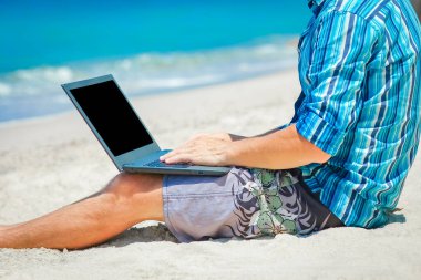 Happy man guy with laptop near the seashore weekend travel