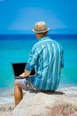 Happy man guy with laptop near the seashore weekend travel