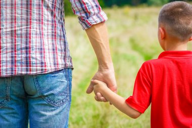 Park aile kavramında mutlu çocuk ve ebeveynin elleri