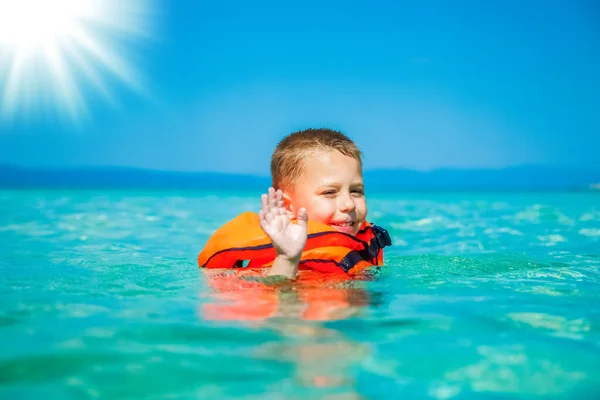 穿着背心的快乐的孩子在海里玩耍 — 图库照片