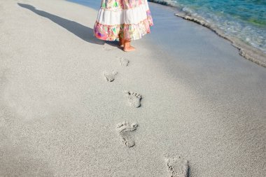 Ayakları kumsalda güzel ayak izleri.