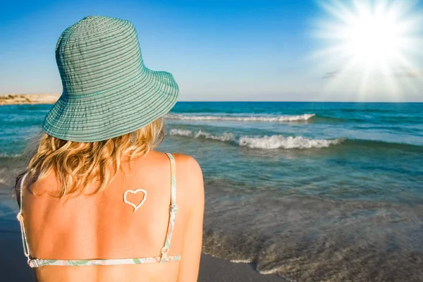 一个快乐的女孩 背着一颗心 站在外面的海边 — 图库照片
