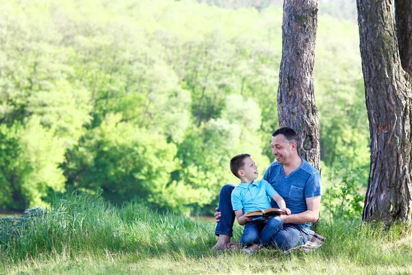 父亲和儿子快乐地阅读圣经 — 图库照片