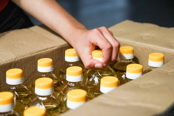 Many Bottles Sunflower Oil Box People Hand Background — Stock Photo, Image