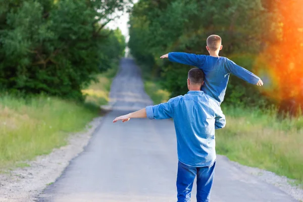 在大自然中 快乐的孩子在父母的肩上走在旅行的路上 — 图库照片