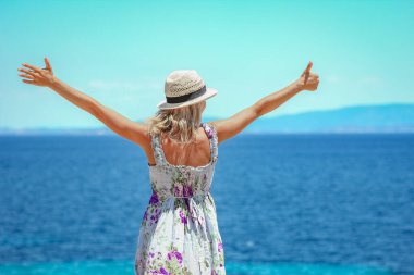 Hafta sonu doğa gezisinde deniz kıyısında mutlu bir kız.