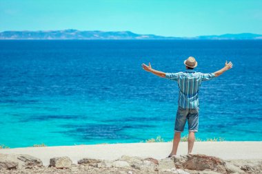 Hafta sonu doğa gezisinde deniz kenarında mutlu bir adam.