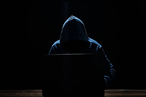 Хакер с ноутбуком сидит за столом и абстрактный двоичный код. Виртуальные программы угрозы деловой жизни.