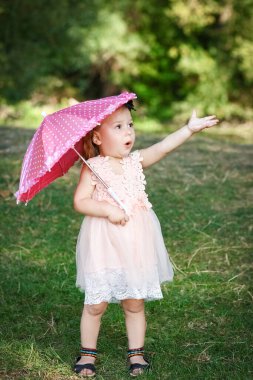 Parkta şemsiyesi olan mutlu bir çocuk.