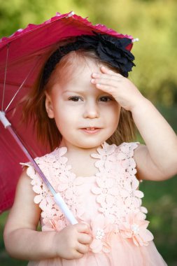Parkta şemsiyesi olan mutlu bir çocuk.