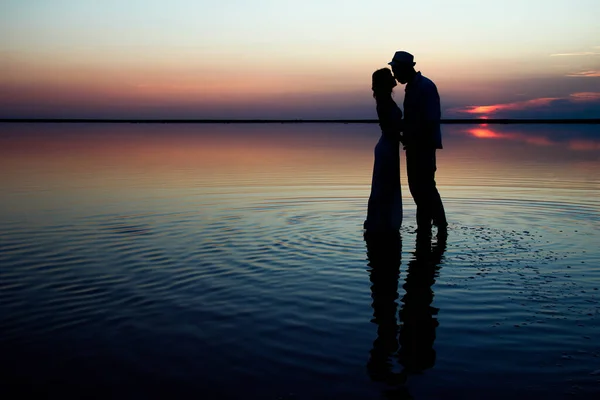 happy couple at sea with water reflection silhouette background