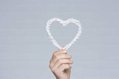 Heart in human hands on white brick background