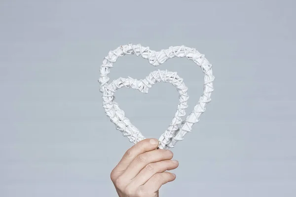 Heart in human hands on white brick background