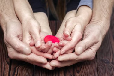 Heart in hands on valentine's day on a wooden background holiday