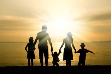 Doğada mutlu bir aile deniz kenarında bir siluette