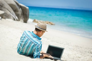 Happy man guy with laptop near the seashore weekend travel