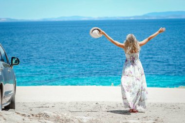 Hafta sonu doğa gezisinde deniz kıyısında mutlu bir kız.