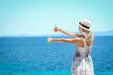 Hafta sonu doğa gezisinde deniz kıyısında mutlu bir kız.