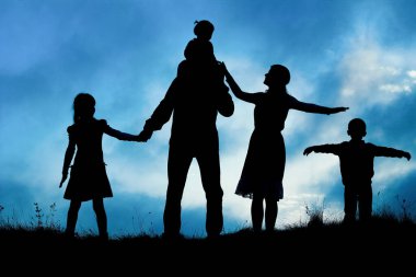 Deniz kenarında mutlu bir aile, doğanın siluetinde.