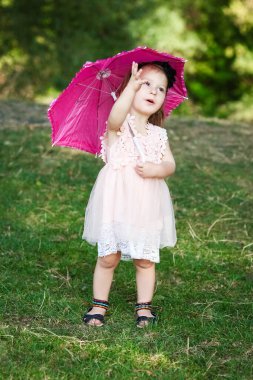 Parkta şemsiyesi olan mutlu bir çocuk.