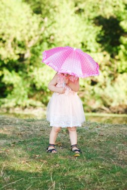 Parkta şemsiyesi olan mutlu bir çocuk.