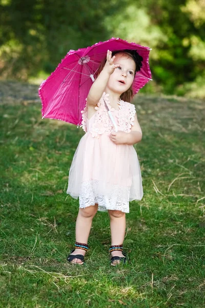 Parkta şemsiyesi olan mutlu bir çocuk.