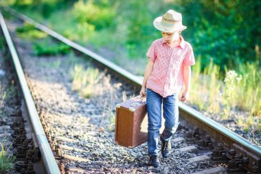 Kovboy çocuk bavulu ve tren yolu batı seyahat konseptiyle
