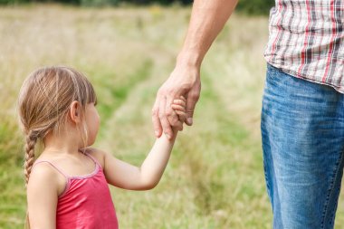 Park aile kavramında mutlu çocuk ve ebeveynin elleri