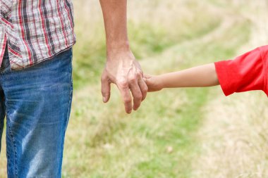 Park aile kavramında mutlu çocuk ve ebeveynin elleri