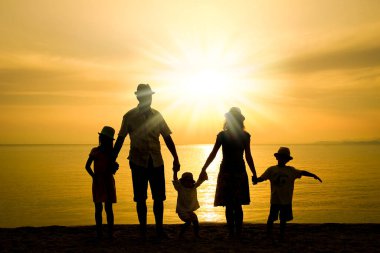 Doğada mutlu bir aile deniz kenarında bir siluette