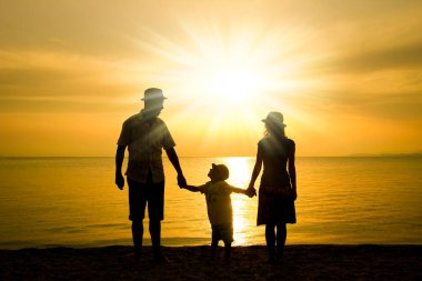 Doğada mutlu bir aile deniz kenarında bir siluette