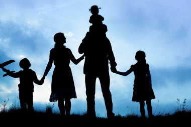 Deniz kenarında mutlu bir aile, doğanın siluetinde.