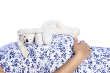 Mutlu hamile kız beyaz arka planda yatıyor.