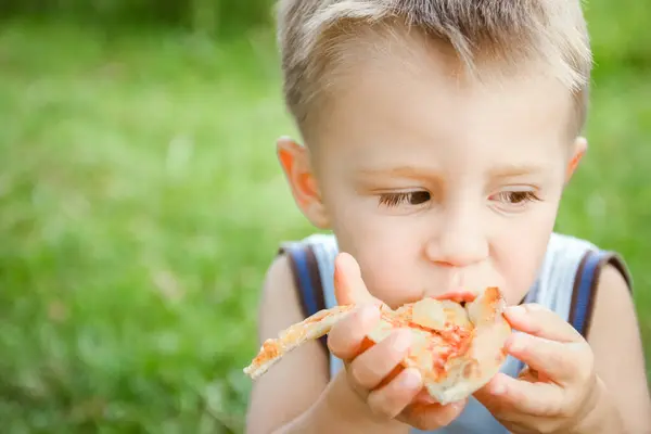 Criança Comendo Uma Pizza Saborosa Sobre Natureza Grama Parque — Fotografia de Stock