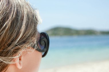 Doğa arka planda denizde güneş gözlüğü ile mutlu kız