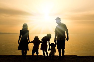 Doğada mutlu bir aile deniz kenarında bir siluette