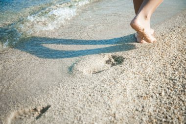 Deniz kıyısındaki ayak ve ayak izleri doğa seyahati arka planında.