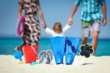 Deniz kenarındaki mutlu aile, terlikleriyle seyahate çıkıyor.