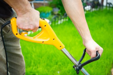 Bahçedeki çim biçme makinesi ve adam