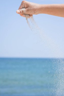 Eller doğaya yolculukta denizden kum döker. Deniz kumlarında tatiller geçer..