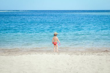 Doğada deniz kenarında oynayan mutlu çocuk.