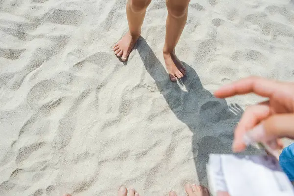 ギリシャ海の砂の中の美しい脚が ロイヤリティフリーのストック画像