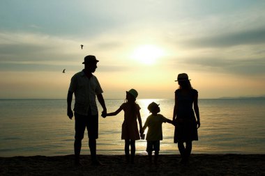 Doğada mutlu bir aile deniz kenarında bir siluette
