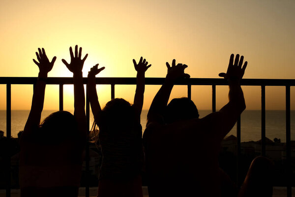 Happy family at the dawn of the sea silhouette background