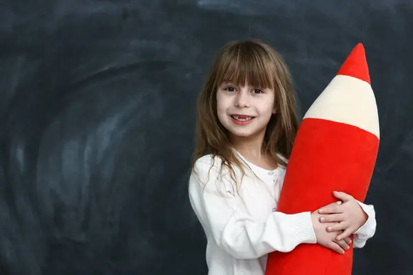 Kleines Mädchen Mit Einem Großen Bleistift Auf Schwarzem Hintergrund Stockfoto