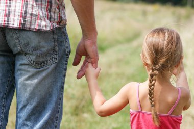 Park aile kavramında mutlu çocuk ve ebeveynin elleri