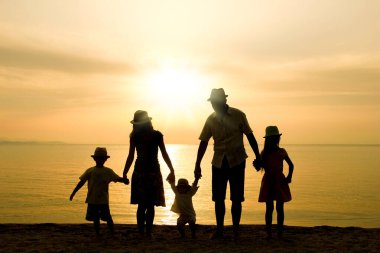 Doğada mutlu bir aile deniz kenarında bir siluette