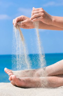 Eller doğaya yolculukta denizden kum döker. Deniz kumlarında tatiller geçer..