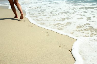 Deniz kıyısındaki ayak ve ayak izleri doğa seyahati arka planında.