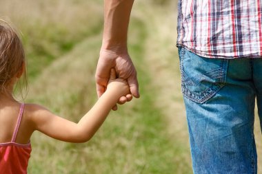 Park aile kavramında mutlu çocuk ve ebeveynin elleri